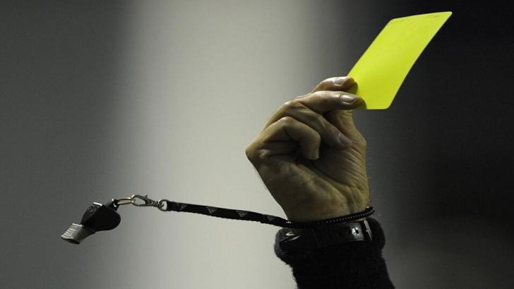 Referee gives player yellow card